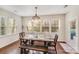 Bright dining area featuring wood floors, rustic table with bench, elegant chandelier, and many windows for natural light at 220 Kenway Loop # 41, Mooresville, NC 28117