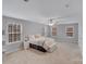 Spacious primary bedroom with neutral carpet, ceiling fan, and natural light from the many windows at 220 Kenway Loop # 41, Mooresville, NC 28117