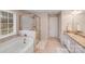 Well-lit bathroom featuring a glass-enclosed shower, soaking tub, and double sink vanity at 220 Kenway Loop, Mooresville, NC 28117