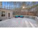 Large deck with modern outdoor furniture offers a serene view of the lush, wooded surroundings at 220 Kenway Loop, Mooresville, NC 28117