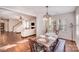 Bright dining room with hardwood floors, modern light fixture and views to the living room and stairs at 220 Kenway Loop, Mooresville, NC 28117