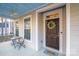 Charming front porch with cozy seating and welcoming wreath on the front door creates a warm curb appeal at 220 Kenway Loop, Mooresville, NC 28117