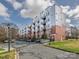 Modern brick apartment building featuring gray siding, black balconies, and ample parking at 2338 Yadkin Ave # 503, Charlotte, NC 28205