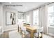 Dining area featuring a modern wooden table, white chairs, and a large window for natural light at 2545 Ellen Ave # 1017A, Charlotte, NC 28208