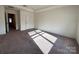 A carpeted bedroom featuring a closet or ensuite bathroom door and large windows at 2623 Aubrey St, Monroe, NC 28110