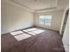 Bright bedroom with natural light and a tray ceiling featuring a large window with outside views at 2623 Aubrey St, Monroe, NC 28110