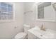 Charming bathroom features a toilet and vanity with mirror, complemented by natural light at 303 Bost St, Kannapolis, NC 28081