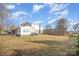 Rear home exterior with spacious yard, sunroom, and additional structure on the property at 303 Bost St, Kannapolis, NC 28081