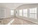 Bright living room featuring vaulted ceiling, vinyl plank floors, ceiling fan, and multiple windows at 303 Bost St, Kannapolis, NC 28081