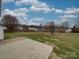 Exterior view of backyard featuring concrete pad, open yard, and partial fencing at 3114 Montcalm Ct, Monroe, NC 28110