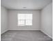 This bedroom is filled with light and has new carpet, white walls, and a window, offering a soothing ambiance at 3114 Montcalm Ct, Monroe, NC 28110