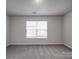 A spacious bedroom with neutral carpeting and a window is bathed in natural light, offering a calm atmosphere at 3114 Montcalm Ct, Monroe, NC 28110