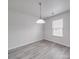 Bright and airy empty room featuring neutral walls, modern light fixture and light-colored wood floor at 3114 Montcalm Ct, Monroe, NC 28110