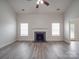 Bright living room featuring a fireplace, ceiling fan, and light gray wood flooring at 3114 Montcalm Ct, Monroe, NC 28110