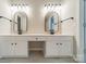 Bright bathroom featuring a double sink vanity with modern fixtures and sleek, black framed mirrors at 3554 Laurenhurst Ln, Charlotte, NC 28270