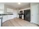 Charming kitchen with white cabinets, black appliances, and wood look flooring at 3554 Laurenhurst Ln, Charlotte, NC 28270