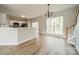 Open-concept living room with a kitchen and bright staircase with hardwood floors at 3554 Laurenhurst Ln, Charlotte, NC 28270