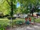 Fenced backyard featuring a table and chairs set, landscaping and several storage buildings at 3701 Seaman Dr, Charlotte, NC 28217