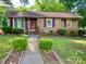 Charming brick home featuring a well-manicured lawn and beautiful, purple accents on the door and shutters at 3701 Seaman Dr, Charlotte, NC 28217