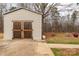 Exterior of an outbuilding featuring double doors, a concrete pad, and surrounding greenery at 4187 Bessie Hudson Rd, Lancaster, SC 29720