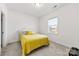 Bright bedroom featuring a sunny window and carpeted floors with a comfortable yellow bed at 4233 Poplin Grove Dr, Indian Trail, NC 28079