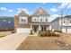 Charming two-story home with brick and gray siding and a two-car garage at 4233 Poplin Grove Dr, Indian Trail, NC 28079