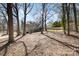 Large backyard with mature trees, shed, deck, and established lawn at 5019 Crooked Oak Ln, Charlotte, NC 28226