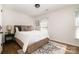 Comfortable bedroom features wood floor, neutral paint, large window, and a decorative rug at 5019 Crooked Oak Ln, Charlotte, NC 28226