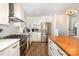 Bright, modern kitchen features stainless steel appliances, sleek white cabinets, and butcher block countertops at 5019 Crooked Oak Ln, Charlotte, NC 28226