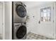 Efficient laundry room with stacked washer and dryer, plus patterned tile flooring at 5019 Crooked Oak Ln, Charlotte, NC 28226