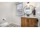 Charming powder room with a modern vanity, round mirror, and patterned tile floor at 5019 Crooked Oak Ln, Charlotte, NC 28226