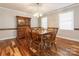 Formal dining room featuring hardwood floors, a wooden table, and a display cabinet at 5789 Gettysburg Nw Dr, Concord, NC 28027