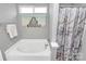 A bathtub featuring a showerhead, curtain, and window for natural light at 5830 Kelden Walker Ln, Charlotte, NC 28269