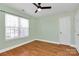 A light-filled bedroom with ceiling fan, wood floors, and a window at 5830 Kelden Walker Ln, Charlotte, NC 28269