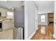 Inviting hallway showcasing hardwood floors leading to a kitchen with stainless steel appliances and a fireplace at 5830 Kelden Walker Ln, Charlotte, NC 28269