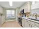 Bright kitchen with stainless steel appliances, white cabinets, complemented by tile flooring and quartz countertops at 5830 Kelden Walker Ln, Charlotte, NC 28269