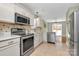 Bright kitchen featuring white cabinets, stainless steel appliances, and stylish countertops at 5830 Kelden Walker Ln, Charlotte, NC 28269