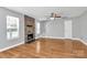 Spacious living room featuring hardwood floors, a ceiling fan, and a stone fireplace at 5830 Kelden Walker Ln, Charlotte, NC 28269