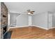 Hardwood living room featuring a stone fireplace, ceiling fan, and stairway at 5830 Kelden Walker Ln, Charlotte, NC 28269