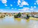 Scenic aerial view of a house nestled near a tranquil lake, surrounded by lush greenery and clear blue skies at 6325 Martin Lake Rd, Charlotte, NC 28227