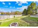 Backyard with a fire pit and fence overlooking water at 6325 Martin Lake Rd, Charlotte, NC 28227