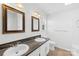 Bathroom with double vanity, framed mirrors, dark countertop, and wood-look floor at 6325 Martin Lake Rd, Charlotte, NC 28227