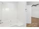 All-white bathroom featuring a bathtub with a showerhead and tile surround at 6325 Martin Lake Rd, Charlotte, NC 28227