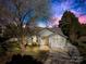 Charming single-Gathering home featuring a well-manicured lawn and a blossoming tree under an evening sky at 6325 Martin Lake Rd, Charlotte, NC 28227