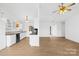 Open-concept kitchen with white cabinets, black appliances and counter tops, and hardwood floors at 6325 Martin Lake Rd, Charlotte, NC 28227