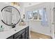 Stylish bathroom with elegant vanity, round mirror, decorative lighting, and a window at 717 Meadow Lake Dr, Matthews, NC 28105