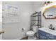 Cozy half bathroom with decorative mirror, a single sink vanity, and modern toilet at 717 Meadow Lake Dr, Matthews, NC 28105