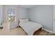 Bright bedroom with a window, wood laminate flooring, and a decorative pillow on the bed at 717 Meadow Lake Dr, Matthews, NC 28105