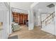 Spacious foyer with staircase and view into the office with custom built-in shelves at 717 Meadow Lake Dr, Matthews, NC 28105