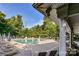 Community pool with lounge chairs, umbrellas, and surrounded by trees at 8412 Westmoreland Lake Dr, Cornelius, NC 28031